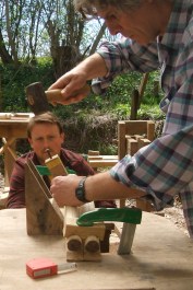 Stephen carefully sighting Hans as he locates where to drill into his chair legs