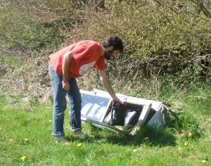 Fransisco replacing one of the water containers back into the solar heater after his shower